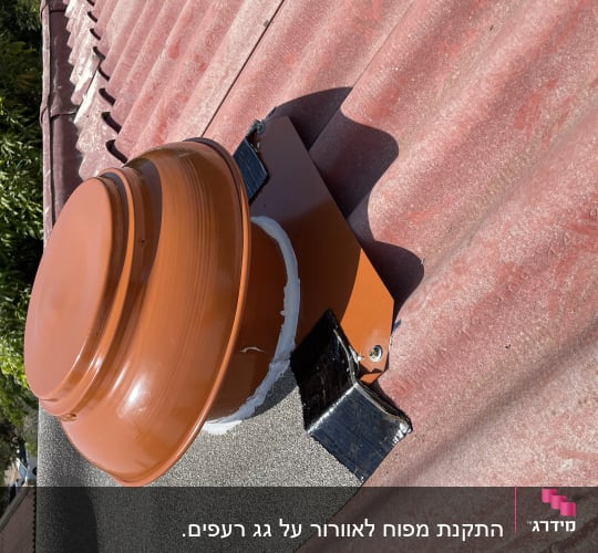 מאוורר כתום מותקן על גג רעפים אדום